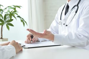 Arzt im Gespräch mit einem Patienten während einer medizinischen Beratung zur möglichen Cannabis-Therapie.
